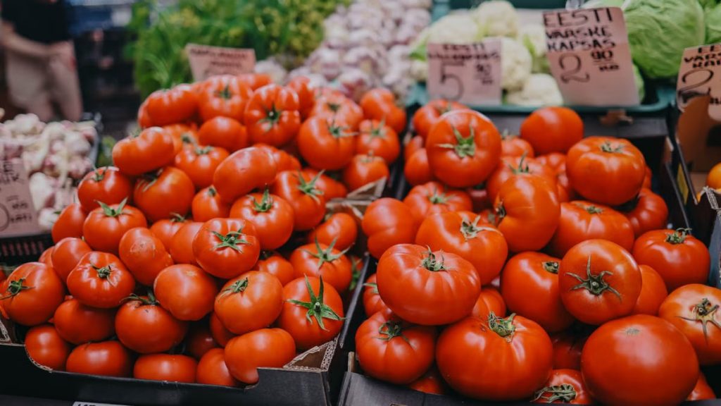 Vibrant red tomatoes on display at an outdoor market, an inviting scene for fresh produce lovers.