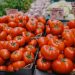 Vibrant red tomatoes on display at an outdoor market, an inviting scene for fresh produce lovers.